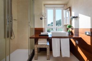 a bathroom with a sink and a glass shower at Hotel de Charme Casa da Amieira in Amiães de Cima