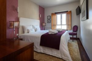 a hotel room with a bed and a window at Hotel de Charme Casa da Amieira in Amiães de Cima