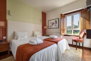 a hotel room with two beds with towels on them at Hotel de Charme Casa da Amieira in Amiães de Cima