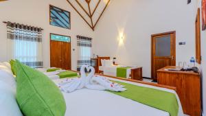 a bedroom with four beds with towels on them at Akash Treehouse in Sigiriya