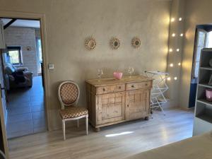 a room with a wooden dresser and a chair at La petite maison in Lagorce