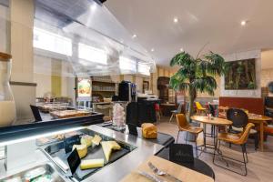 a restaurant with a counter with tables and chairs at Hôtel Saint Albert in Sarlat-la-Canéda