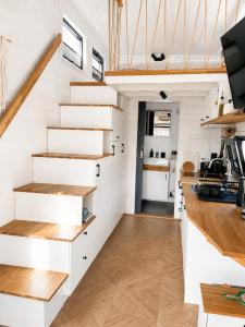 a white staircase in a tiny house with a kitchen at Tinyhaus Marie von Tinyhaus Steinhude in Steinhude