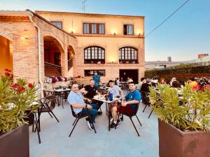 a group of people sitting at tables in a patio at Cella del Palancar in Motilla del Palancar