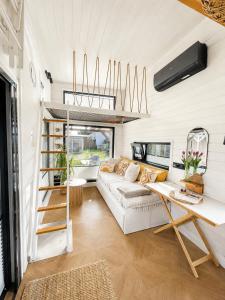 a living room with a white couch and a table at Tinyhaus Marie von Tinyhaus Steinhude in Steinhude