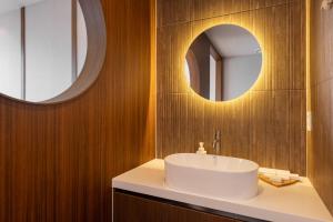 a bathroom with a white sink and two mirrors at Marysol Stay in Busan +153 photos