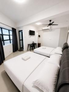 two beds in a room with a ceiling fan at Hotel Casaria in Paka +28 photos