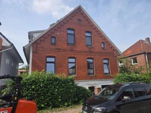 a brick building with a car parked in front of it at Die Stader Auszeit in Stade