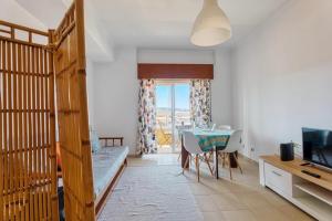 a bedroom with a bunk bed and a table and a television at Only 10 min from Lisbon city centre, 15 min driving from the beaches! in Almada