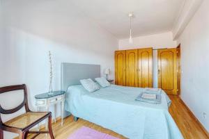 a bedroom with a bed with a chair and a desk at Only 10 min from Lisbon city centre, 15 min driving from the beaches! in Almada