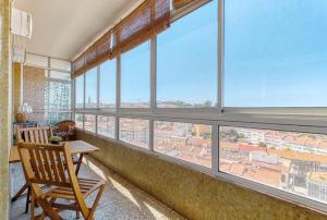 a room with a large window with a chair and a table at Only 10 min from Lisbon city centre, 15 min driving from the beaches! in Almada