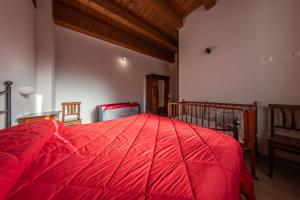 a bedroom with a red bed in a room at Tenuta Giave - nel cuore dell'Irpinia in Montemarano