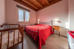 a bedroom with a red bed and a window at Tenuta Giave - nel cuore dell'Irpinia in Montemarano