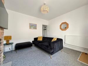 a living room with a black couch and a table at Waterloo Street in King's Lynn
