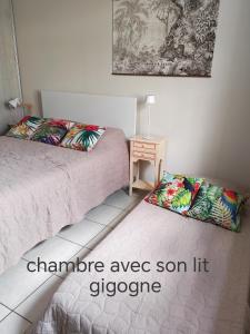 a bedroom with two beds and a side table at Chambre du merle in Illats
