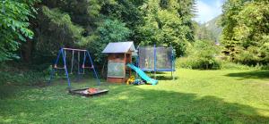 a playground with a slide and a playset in a yard at Chata Turík in Turík +56 photos
