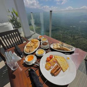a wooden table with plates of breakfast foods on it at A'lanka luxury hotel in haputale in Walhaputenna