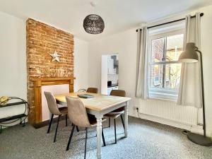 a dining room with a table and chairs and a brick wall at Waterloo Street in King's Lynn