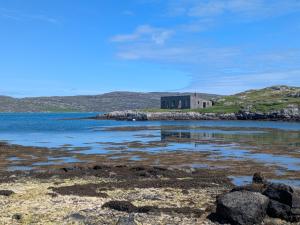 a house on a small island in the ocean at Pod Beag beside the sea Isle of Eriskay in Eriskay