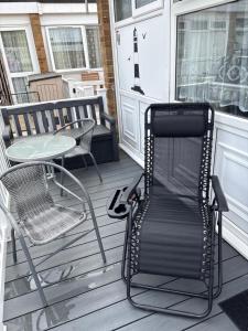 a chair and a table on a porch at 78 Belle Aire in Hemsby +5 photos