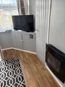 a living room with a flat screen tv on a cabinet at 78 Belle Aire in Hemsby
