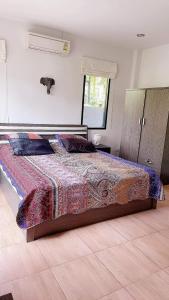 a bedroom with a bed with a colorful blanket on it at Palm Oasis in Nathon Bay
