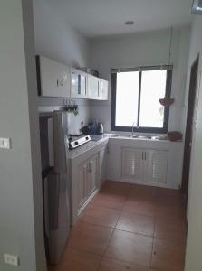 a kitchen with white cabinets and a window at Palm Oasis in Nathon Bay