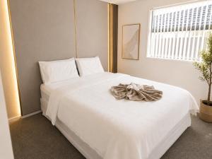 a bedroom with a white bed with a robe on it at The Gem - 5 bedroom brand new house in Christchurch