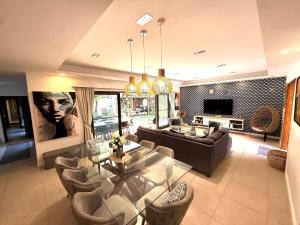 a living room with a couch and a table and chairs at ORCHID Villa luxueuse avec piscine privée- A 600m de la plage in Pereybere
