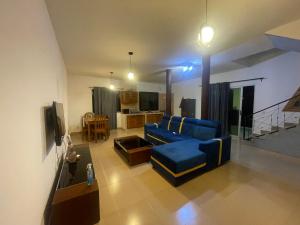 a living room with a blue couch and a kitchen at Villa 4 in Saly Portudal