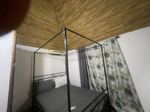 a bed in a room with a wooden ceiling at Villa 4 in Saly Portudal