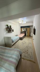 a living room with two beds and a rug at Радуга in Chon-Sary-Oy