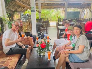 a group of people sitting on a table at Turtle Paradise in Tangalle