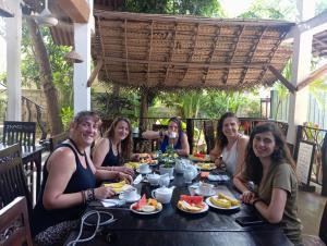 a group of women sitting at a table eating food at Turtle Paradise in Tangalle
