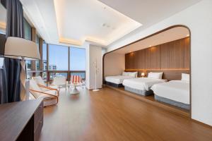 a hotel room with two beds and a large mirror at Marysol Stay in Busan