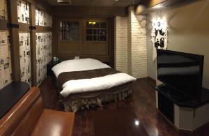 Hotel Piatt (Adult Only) في ناغويا: غرفه فيها سرير وتلفزيون