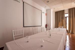 a meeting room with a long table with wine glasses at Hotel Tugasa Villa de Algar in Algar +78 photos