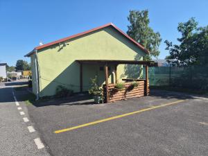 a parking lot with a green building at Apartmány Mácháč in Doksy +2 photos