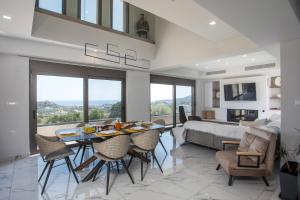 a living room with a table and chairs and a couch at Aetheria Luxury Villa in Kalithies