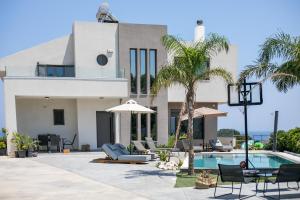 a house with a swimming pool and palm trees at Aetheria Luxury Villa in Kalithies