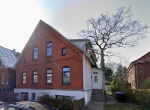 a red and white brick building with a tree at Der Stader Fernblick in Stade