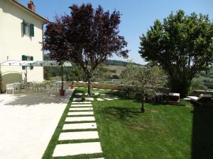 a garden with trees and a table and chairs at A Family Tale - Una Storia Di Famiglia in Monterchi