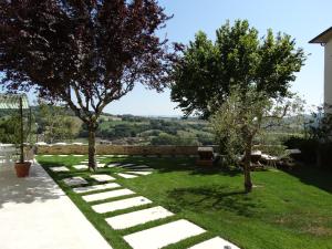 a garden with trees and a stone pathway at A Family Tale - Una Storia Di Famiglia in Monterchi +12 photos