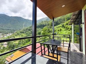 a balcony of a house with a table and chairs at Penance Homestay in Khokna