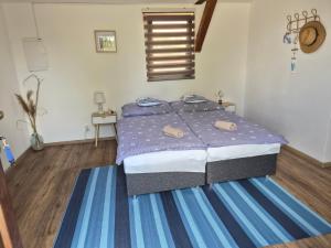 a bedroom with a bed with blue and white sheets at Apartmány Mácháč in Doksy