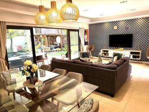 a living room with a couch and a table at ORCHID Villa luxueuse avec piscine privée- A 600m de la plage in Pereybere