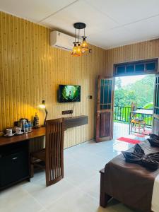 a bedroom with a desk and a bed and a television at Liana Guest House Ella in Ella