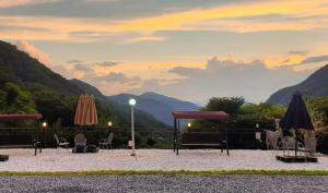 a patio with chairs and umbrellas with a view of mountains at Danyang Euljeon 56 Pension in Danyang