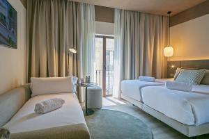a hotel room with two beds and a window at Andante Princesa in Barcelona