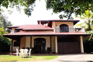 a house with white chairs in front of it at Gondolas Holiday Lanka in Ragama